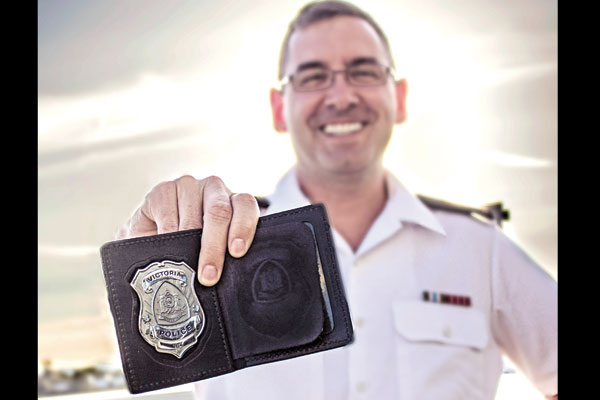 Reservist PO1 LeBlanc shows his Victoria Police Department badge while sporting his military uniform.