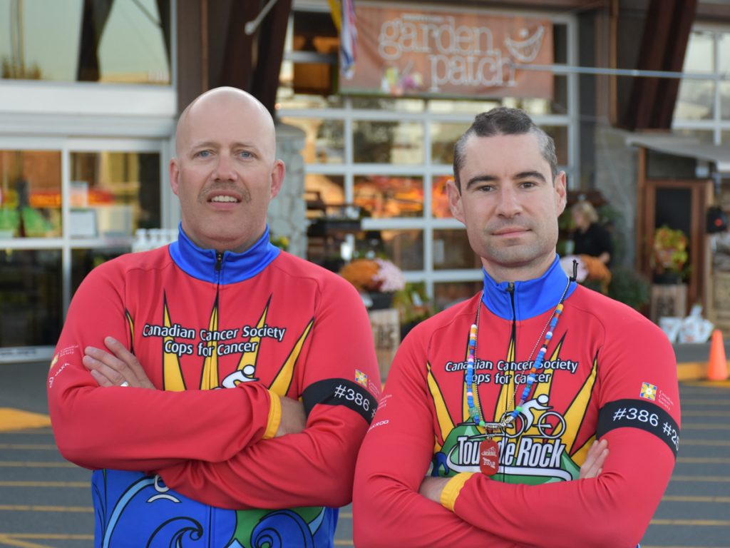 Tour de Rock riders (left) Matt Arnsdorf of CFB Esquimalt Fire and Rescue and SLt Antoine LeBlanc of the Military Police Unit Esquimalt pose for a photo during a stop in Comox