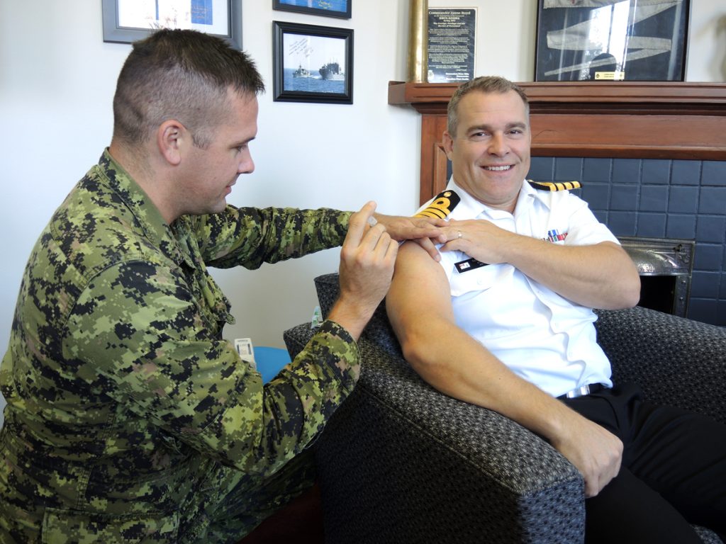 Lieutenant Brian Plinke of Canadian Forces Health Services (Pacific) gives a Flu shot to Base Commander