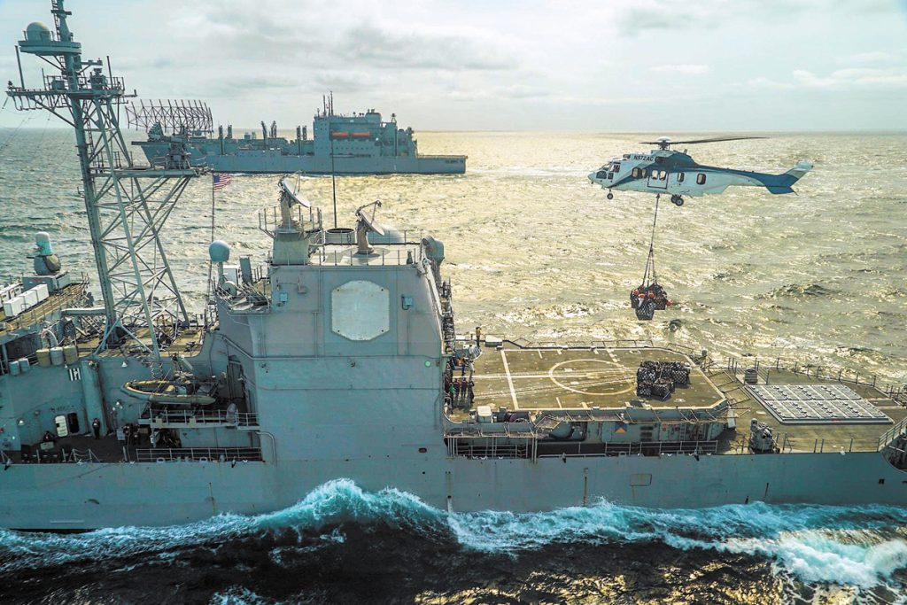 USS Lake Eerie conducts re-supply via helicopter with M/V Asterix in the background. Photo by Cpl Evans