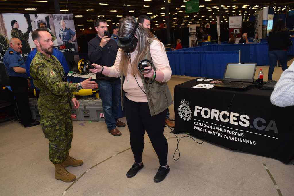 Sgt Tim Keith from CFRC assists a student as she experiences the CAF through virtual reality. This was one of many skilled trades and technology activities available at the 2019 Skills Canada National Competition