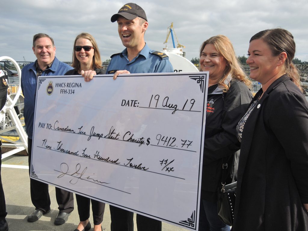 MS Jeffrey Haines of HMCS Regina presents a cheque for $9