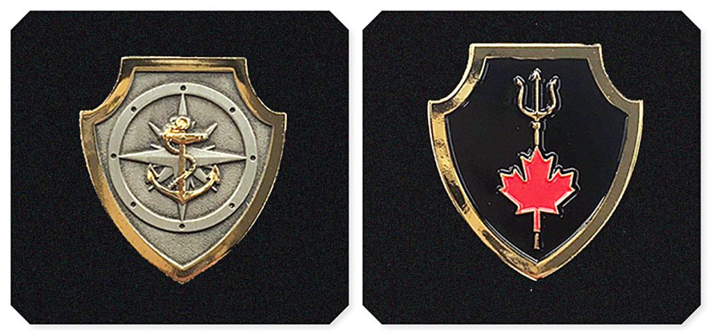 Badge 1 (left): The Naval Boarding Party Basic Qualification badge is a silver shield bordered by gold trim three centimetres in height. A stylized naval compass is centred on the shield in the background with a gold fouled anchor centred on top of the compass. Badge 2 (right): The NTOQ badge is a black shield encased in gold trim three centimetres in height. A gold trident is centred in the background with a red maple leaf centred on the staff of the trident.  Photos by DND