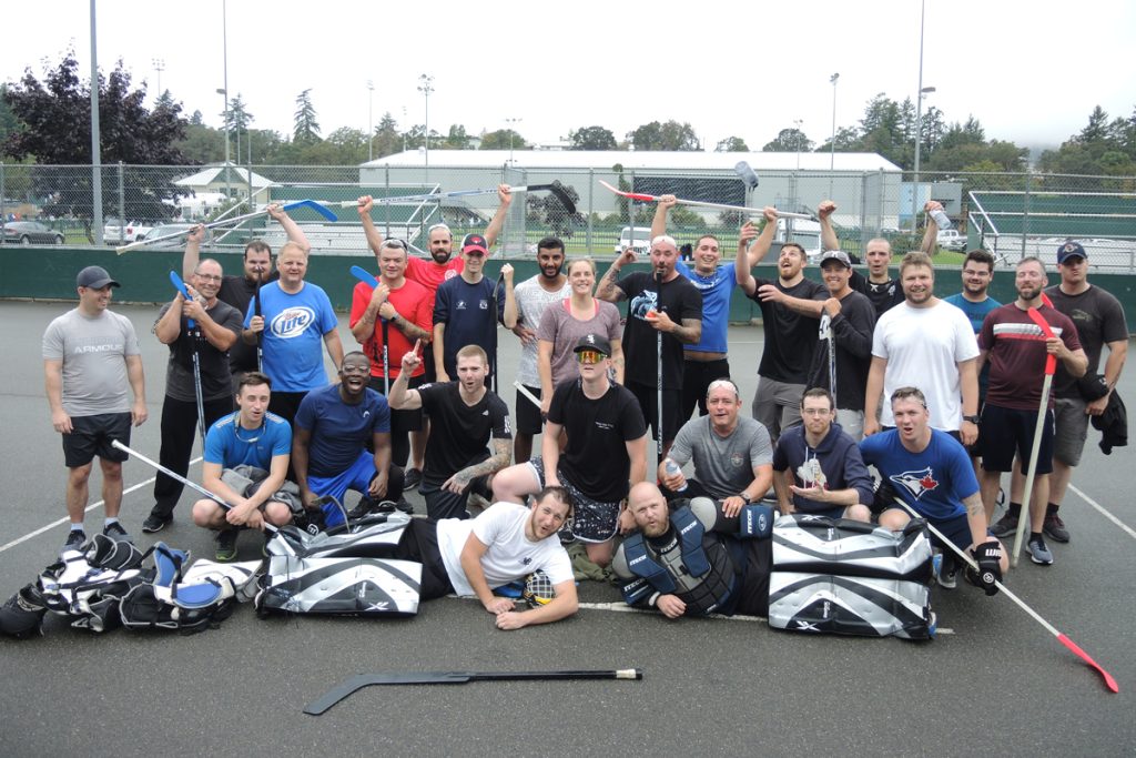Ball hockey players gather for a celebratory group photo following the conclusion of their game.  Photo by Peter Mallett/Lookout