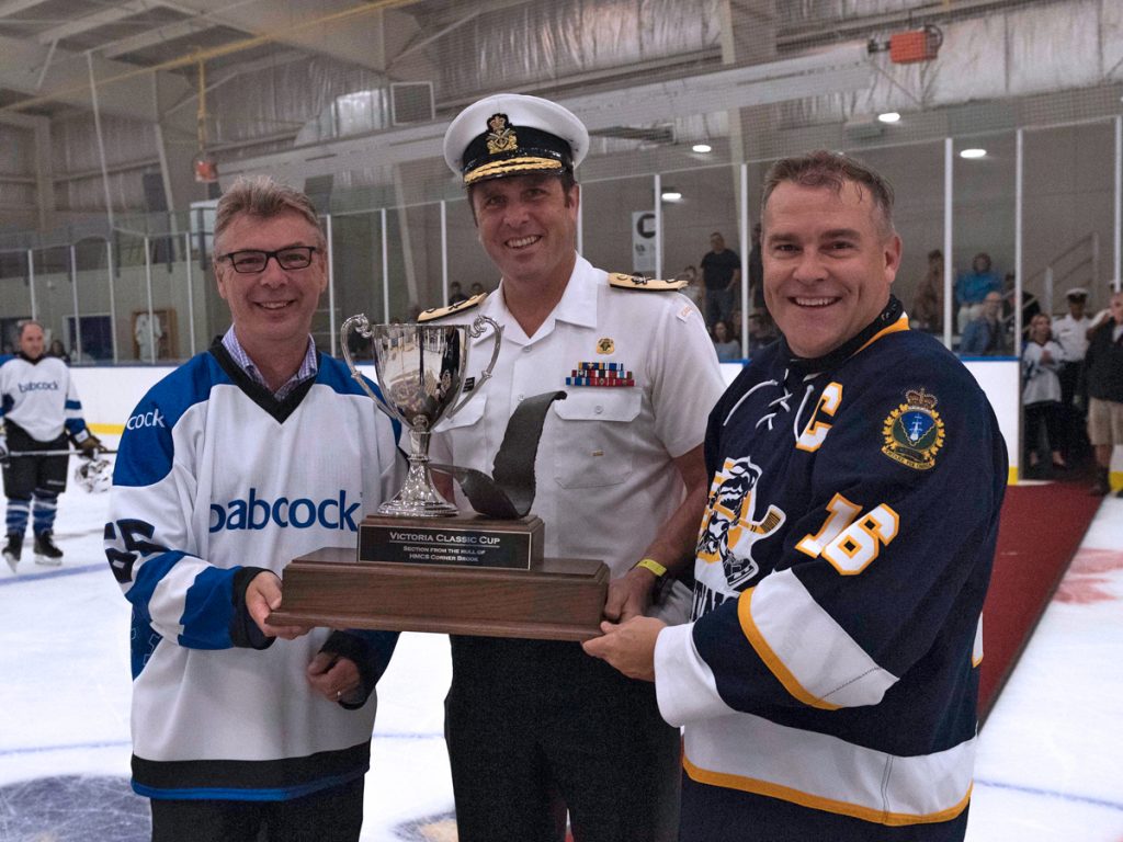 Capt(N) Jason Boyd accepts the Victoria-Class trophy from Commodore Angus Topshee and Babcock Canada’s President Mike Whalley. Photo by LS Bryan Underwood