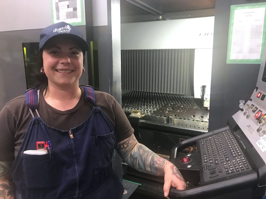 Carmen Collins with a sheet metal laser cutter.