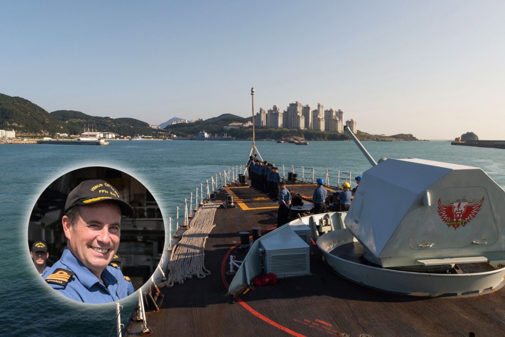 The forecastle cable party and part ship hands stand at attention while coming alongside Busan