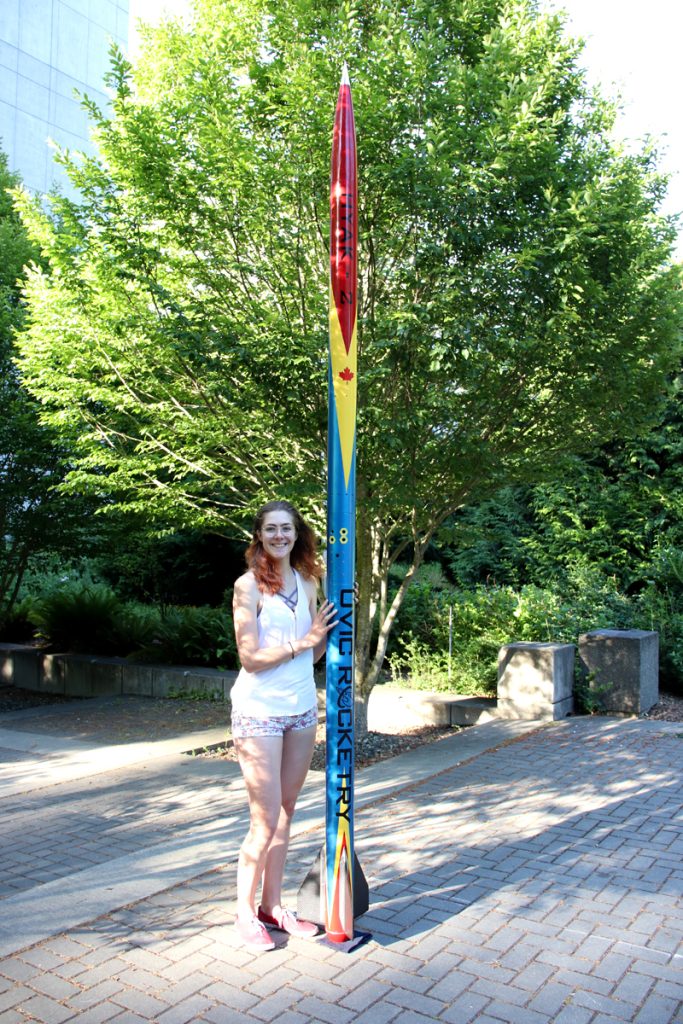 Kelsey Towers-Jones shows off a Hyak-2 rocket used in competition by the UVic Rocketry club. The rocket reached a speed of 2