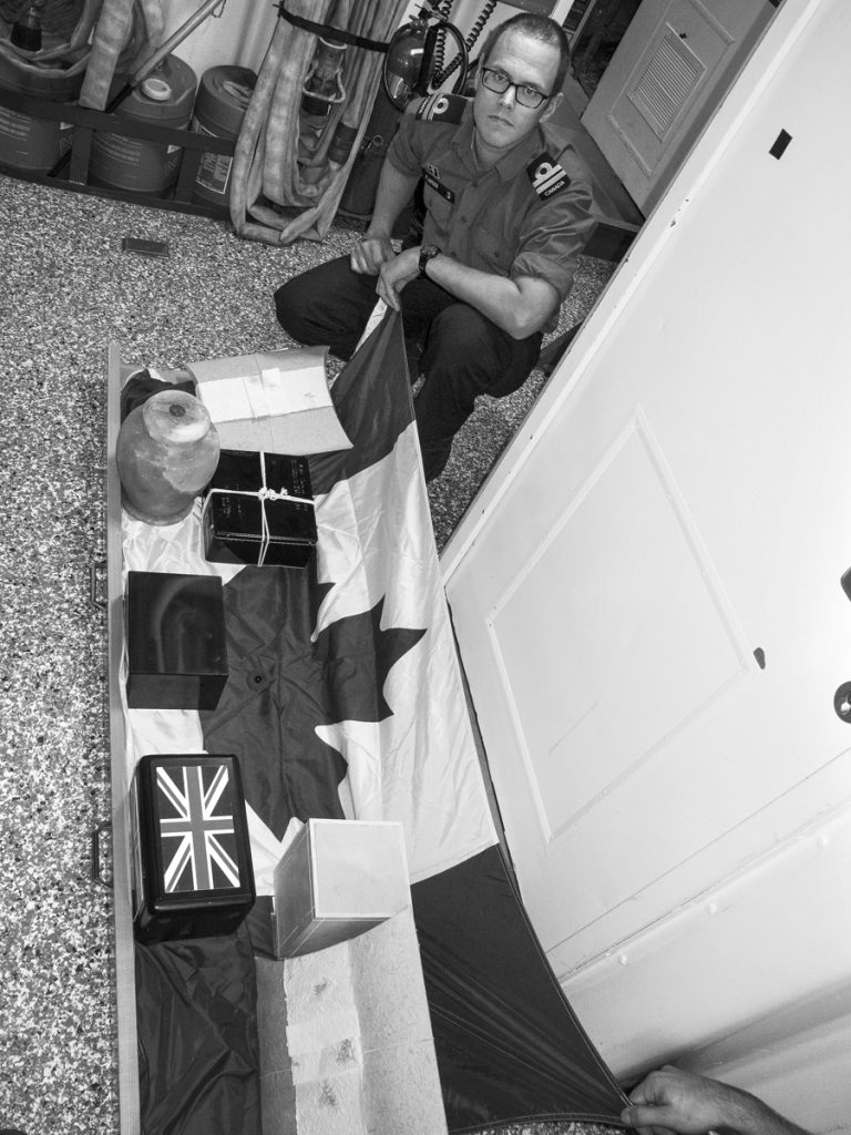 Padre Andrew Klinger prepares the ashes on the sliding board.  Photo by Capt Jenn Jackson