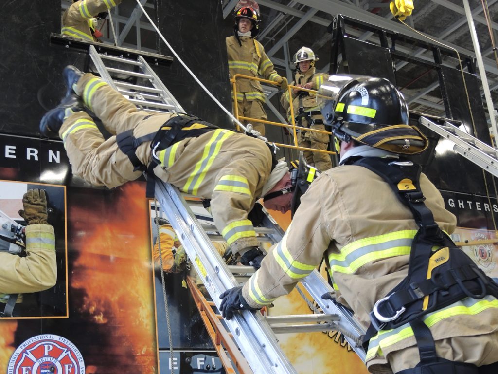 Firefighters from CFB Esquimalt Fire and Rescue practice their ladder bails during an International Association of Firefighters (IAFF) Fire Ground Survival Program. The program is designed to help firefighters across North America escape dangerous life-threatening situations during emergency calls. Photo by Peter Mallett
