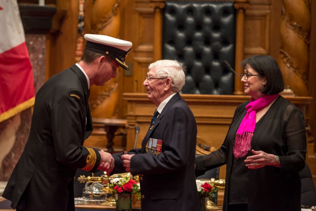 MS (Retired) John Wood shakes hands with Capt(N) Julian Elbourne after receiving a Special Service Medal and Canadian Peacekeeping Service Medal from Lieutenant Governor of B.C. Janet Austin.  Photo by Stephanie Raymond