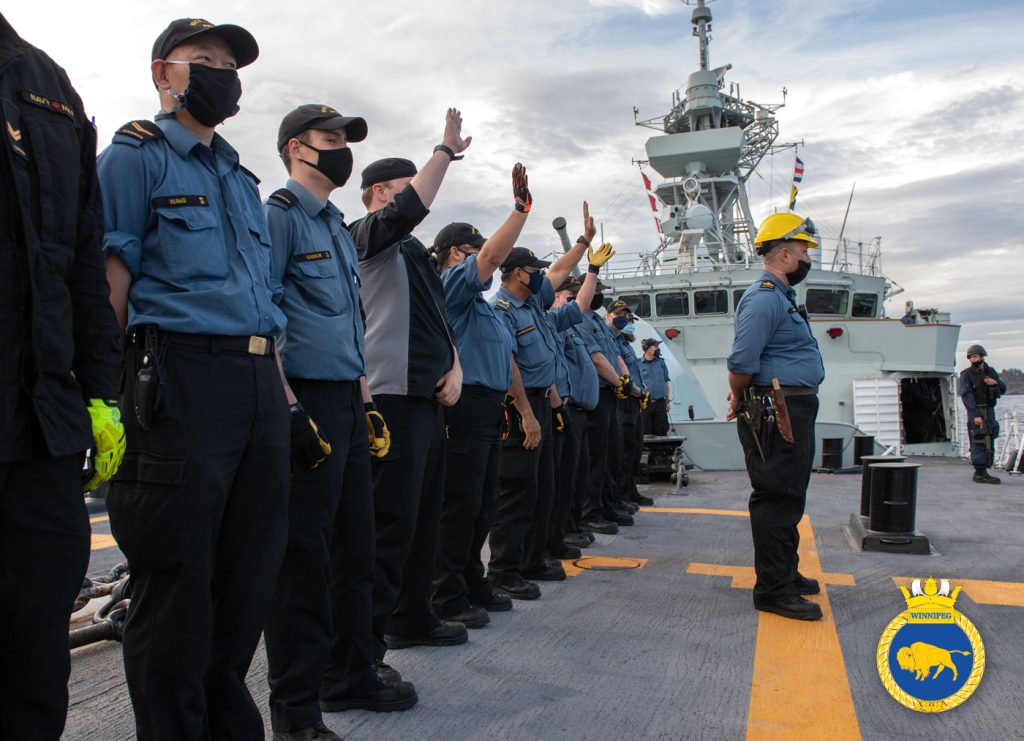 Members of HMCS Winnipeg wave goodbye as the ship departs Esquimalt Harbour Aug. 1. For the first several days at sea