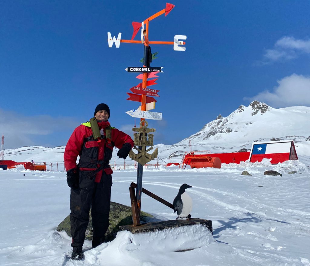A/SLt Kayvan Aflaki stands with a landmark signpost at Captain Arturo Prat Base